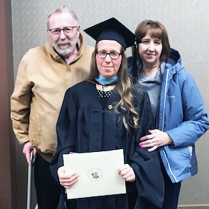 This is a photo of Amanda Otero with her parents, Ron and Tami Bakeberg, during her graduation ceremony at Saint Mary’s.